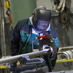 Industrial operator setting  computer controlled process of orbital welding machine in inox pipes...