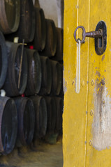 Door witn keys of old cellar with barrels background