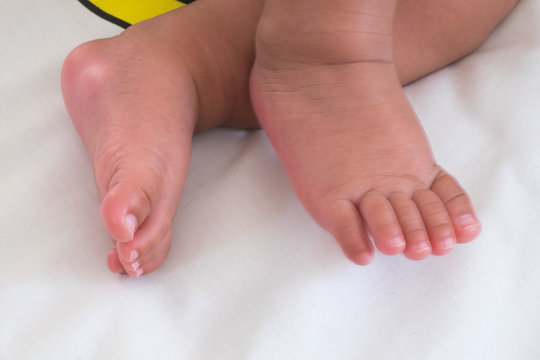 Feet small baby on a white bed