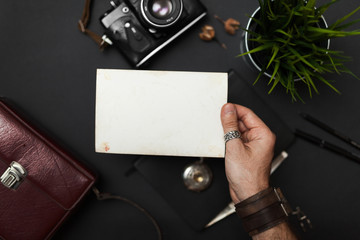Obraz premium Photo in the hand, vintage style, on the black table