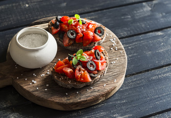 Tomatoes and olives bruschetta  on dark rustic wooden background