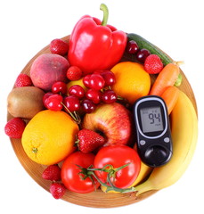 Glucometer with fruits and vegetables on wooden plate