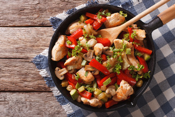 Stir Fry Chicken with mushrooms, peppers and zucchini on a pan close-up. Horizontal top view
