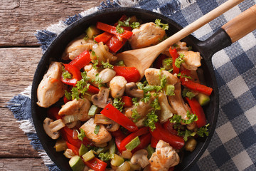 chicken breast with mushrooms and vegetables on a pan close-up. Horizontal top view
