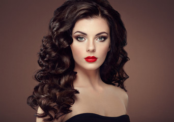 Fototapeta premium Brunette woman with curly hairstyle. Beautiful girl with long wavy hair. Perfect makeup. Fashion photo