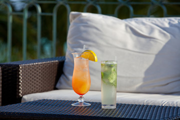 Two fresh cold tasty alcohol cocktails served outdoor on resort.