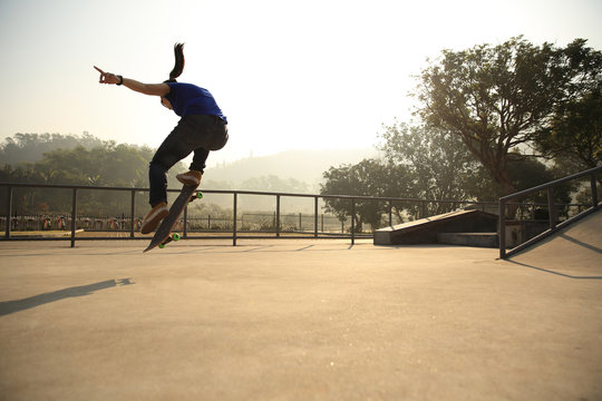 skateboarding woman practice ollie at skatepark