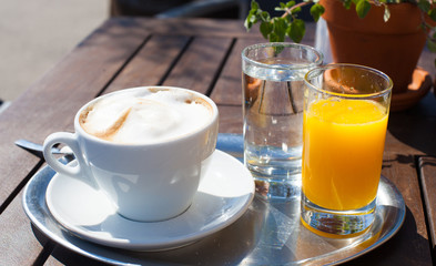 Bottle of Freshly squeezed orange juice sitting on a rustic wooden table.