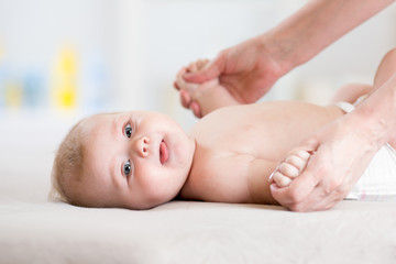 Baby 5 months massaging. Kid lying on the back