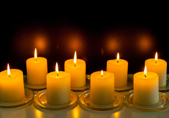 closeup to burning candles in darkness