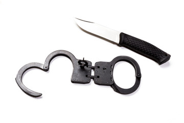 Obraz premium Handcuffs and knife on white isolated background