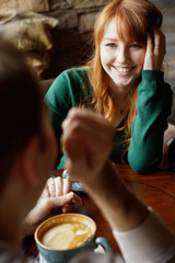 Smiling red-haired woman looking at her boyfriend