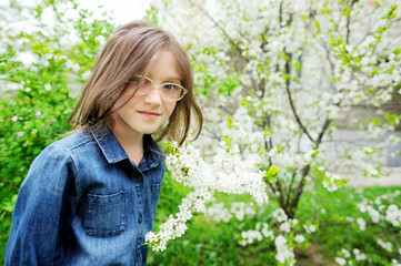 Fototapeta na wymiar Kid girl in blooming garden