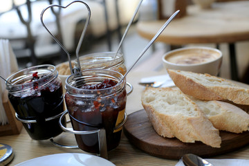 Breakfast, three jars of jam and sliced bread