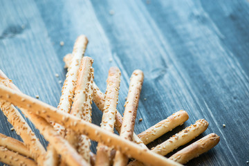 Bunch of homemade grissini breadsticks on wooden surface