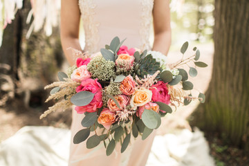 Bride in pink dress with beautiful bouquet
