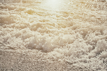 Fototapeta na wymiar Sea wave splashing to the coast, natural vintage sunny background