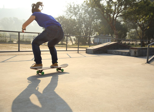 skateboarding woman practice ollie at skatepark