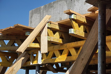 Heavy wooden beams and girders supporting construction of a concrete floor in the newly constructed building