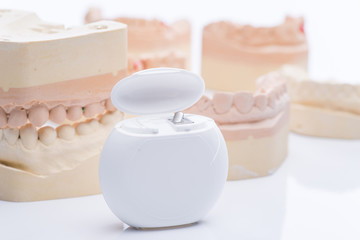 Fototapeta na wymiar Teeth molds with dental floss on a bright white table