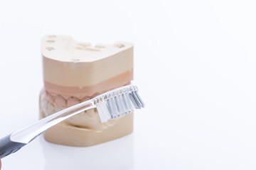 Teeth molds with toothbrush on a bright white table