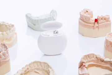 Obraz na płótnie Canvas Teeth molds with dental floss on a bright white table