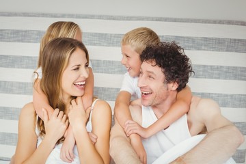 Joyful family playing together on bed