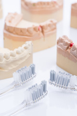 Teeth molds with toothbrush on a bright white table