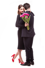 Young sweet couple with lila tulips on white background