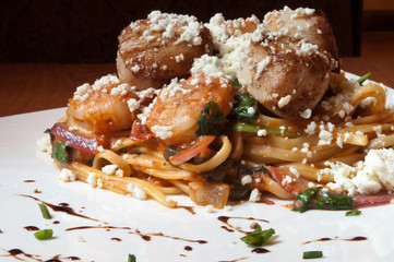 Seafood linguine in a tomato sauce, served with scallops, shrimp and feta cheese.