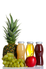 glass bottles of juice and an Apple with grapes and pineapple isolated on white background