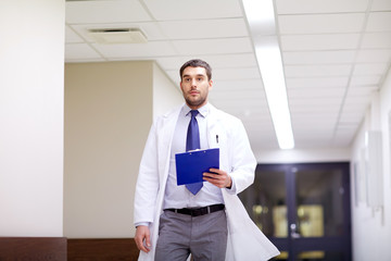 doctor with clipboard walking along hospital