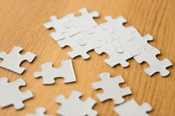 Fototapeta premium close up of puzzle pieces on wooden surface