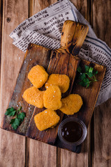 Chicken nuggets with ketchup and sause on chopping board and wooden background. Selective focus