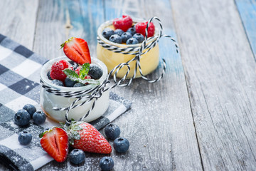 Fresh and healthy natural yogurt with berries on wooden table