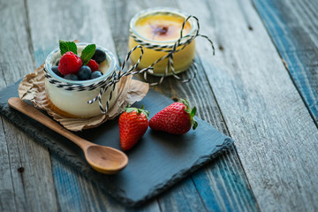 Fresh and healthy natural yogurt with berries on wooden table