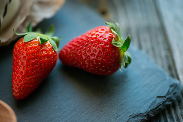 Two strawberries on a rustic stone plate