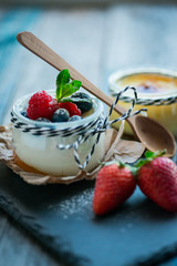 Fresh and healthy natural yogurt with berries on wooden table