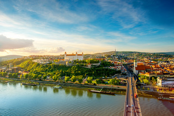 Bratislava aerial cityscape view on the old town with Saint Martin's cathedral, castle hill and Danube river on the sunset in Slovakia. Wide angle view with copy space - obrazy, fototapety, plakaty