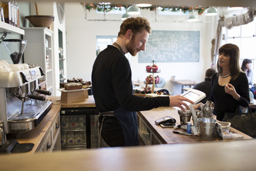  Female Customer Paying In Coffee Shop	
