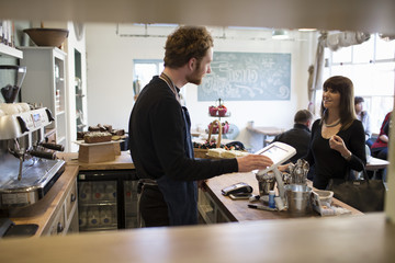  Female Customer Paying In Coffee Shop	