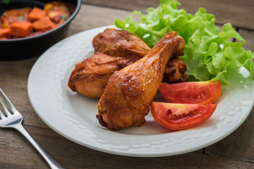 Grilled chicken legs and vegetables on plate