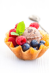 brandy  snaps basket with chocolate ice cream and berries on whi