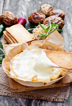 Delicious  baked camembert with roasted potato and toast