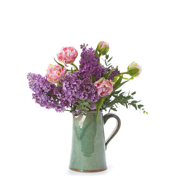 Bouquet of flowers of tulips and lilac in a ceramic jug..