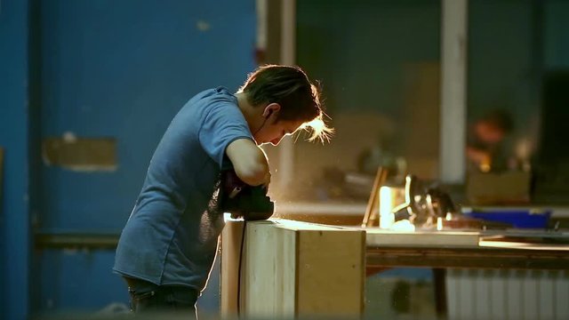 Carpenter polishing wood using electric grinder with polishing extender. close up