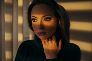 Woman standing indoor in room with sunset