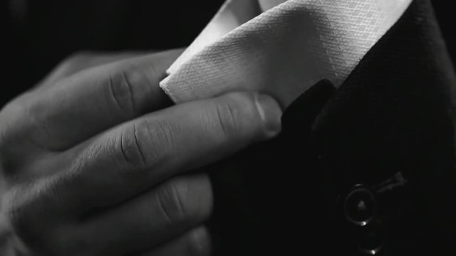 Close up of male hands fastening cufflinks on sleeve of business suit