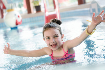 Cute Smiling Little Girl Playing at Indoor Pool