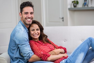 Portrait of romantic couple hugging on sofa